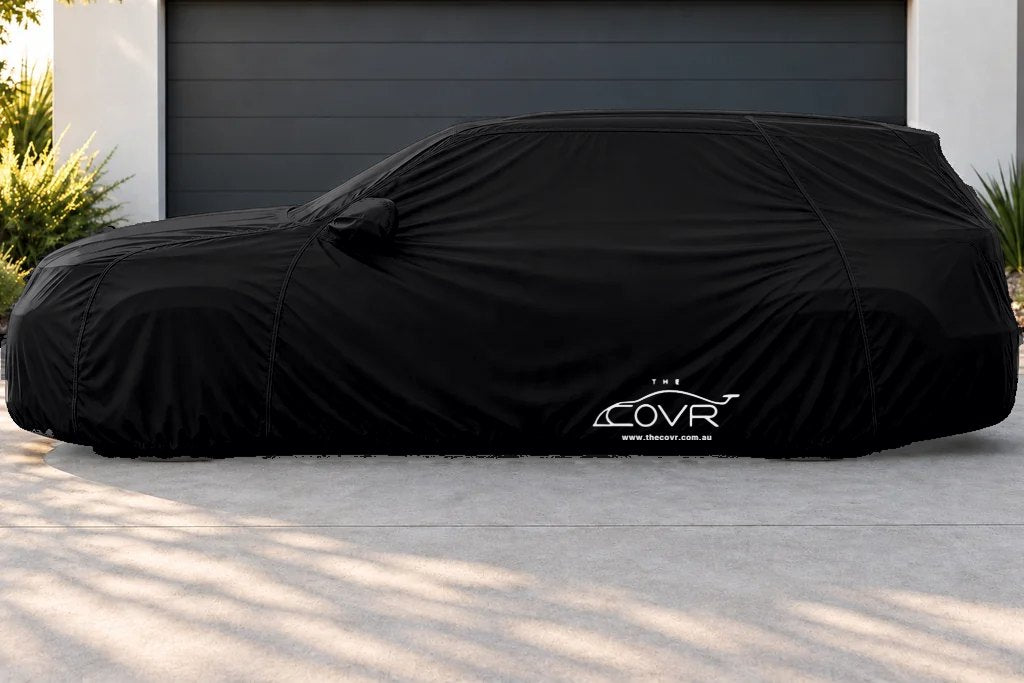 An Outdoor cover fitted over an SUV on a driveway, seen from the side