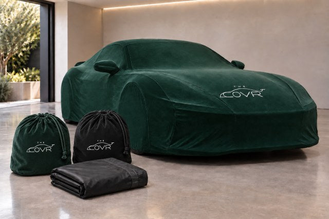 A green cover with a printed mark on a car, beside two matching storage cases