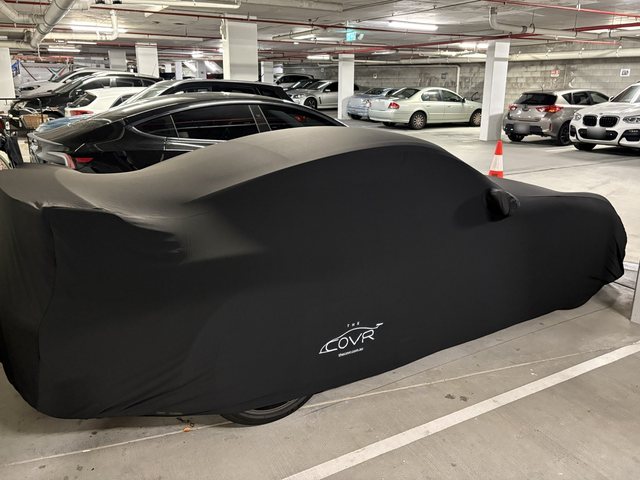 The Covr Indoor cover on a car in an underground carpark, seen from the side