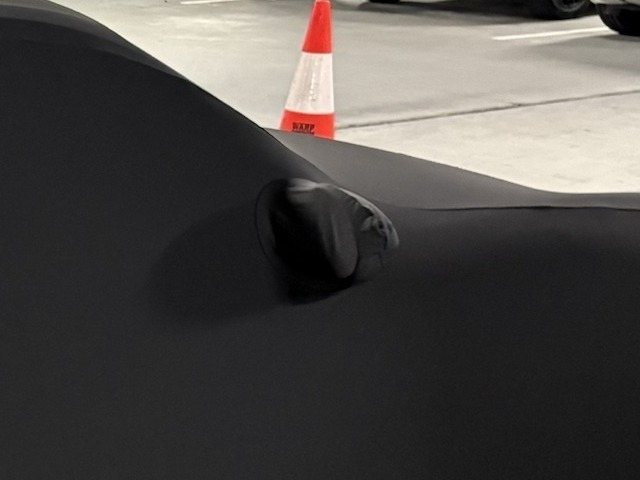 Close-up of the Indoor cover's mirror pocket over the wing mirror, in a carpark